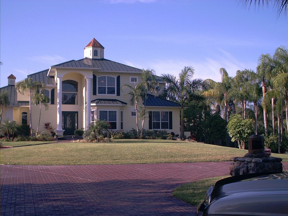 This is an example of a mid-sized traditional one-storey stucco white house exterior in Miami with a hip roof and a shingle roof.