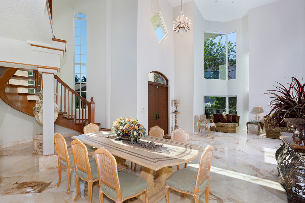 This is an example of an expansive eclectic open plan dining in Miami with white walls, marble floors, no fireplace and multi-coloured floor.