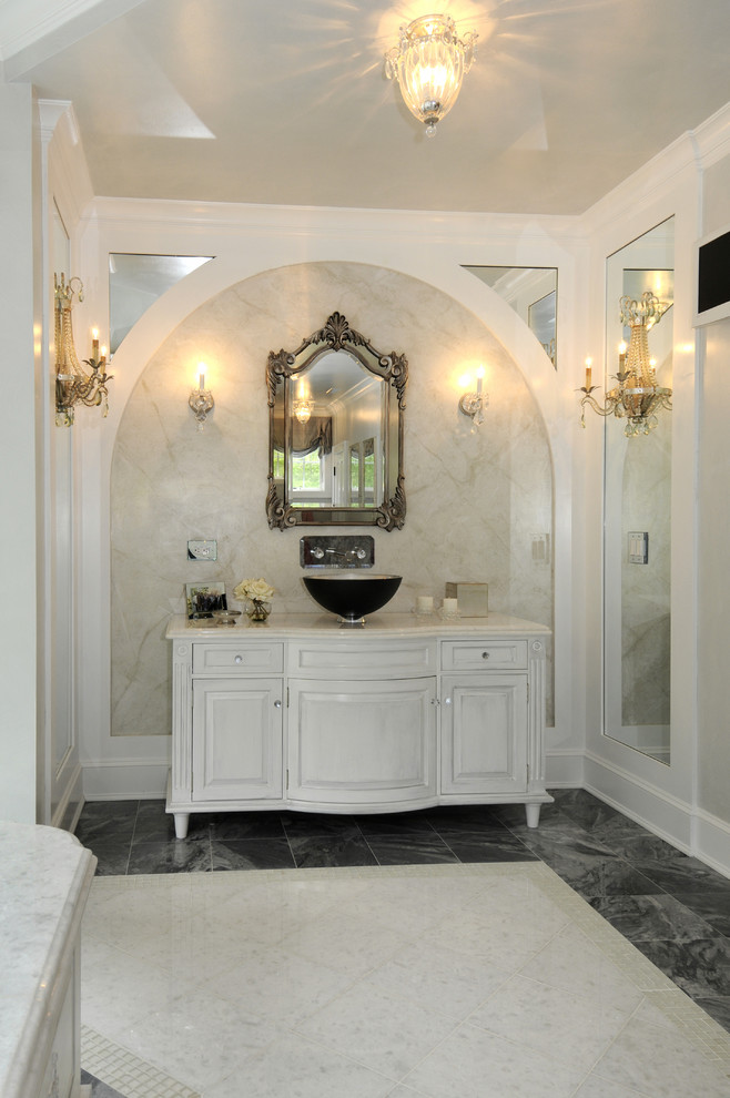 Photo of a large traditional master bathroom in Bridgeport with a vessel sink, raised-panel cabinets, white cabinets, a drop-in tub, a two-piece toilet, black and white tile and grey walls.
