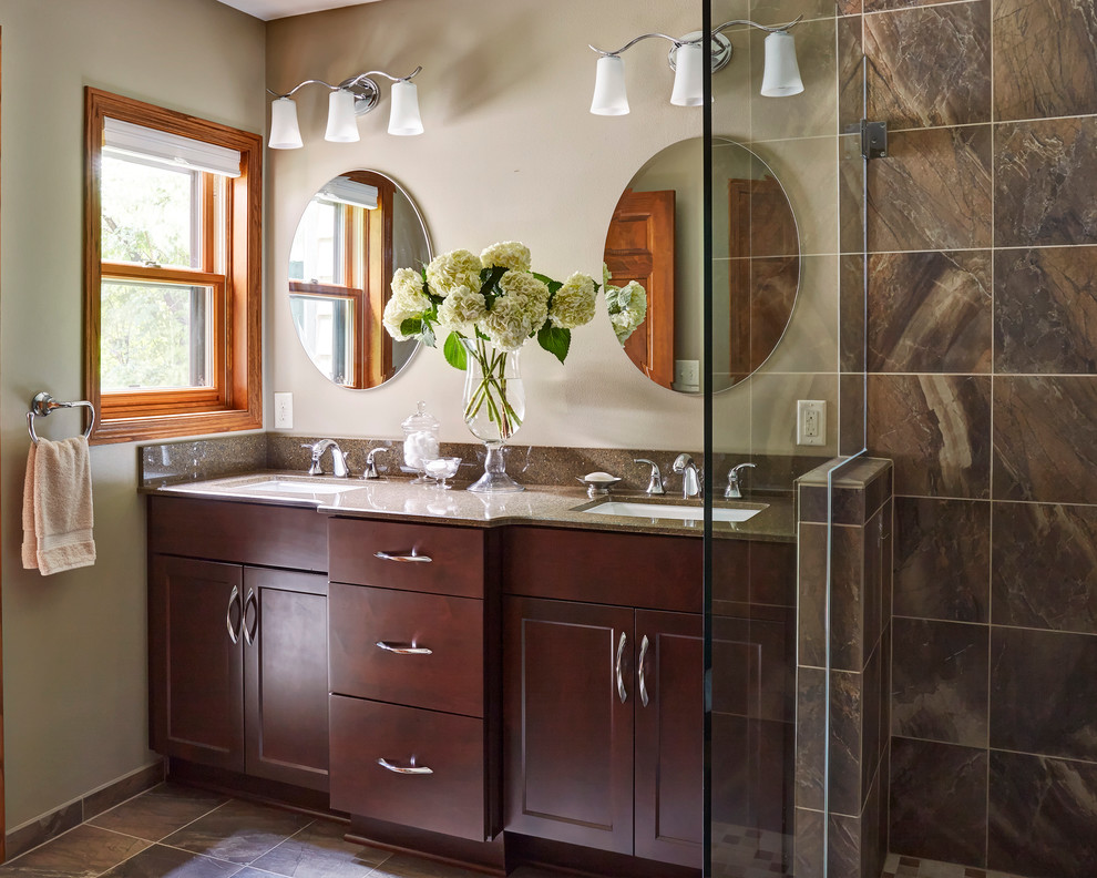 This is an example of a large transitional master bathroom in Milwaukee with shaker cabinets, dark wood cabinets, an open shower, brown tile, porcelain tile, beige walls, porcelain floors, an undermount sink and quartzite benchtops.