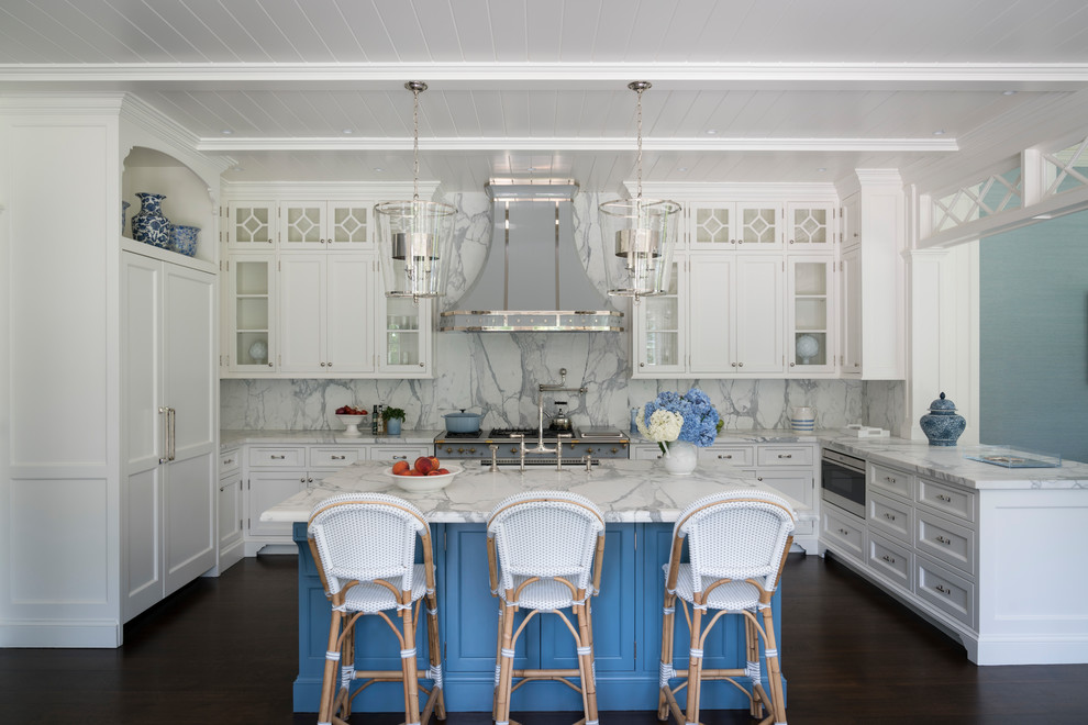 Inspiration for an expansive beach style u-shaped eat-in kitchen in New York with a farmhouse sink, white cabinets, marble benchtops, white splashback, marble splashback, panelled appliances, dark hardwood floors, with island, brown floor and recessed-panel cabinets.