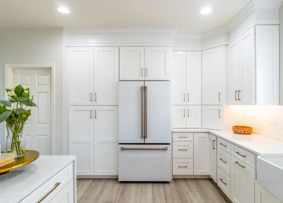Example of a transitional kitchen design in Phoenix with shaker cabinets, white cabinets, quartz countertops, white backsplash, white appliances and white countertops