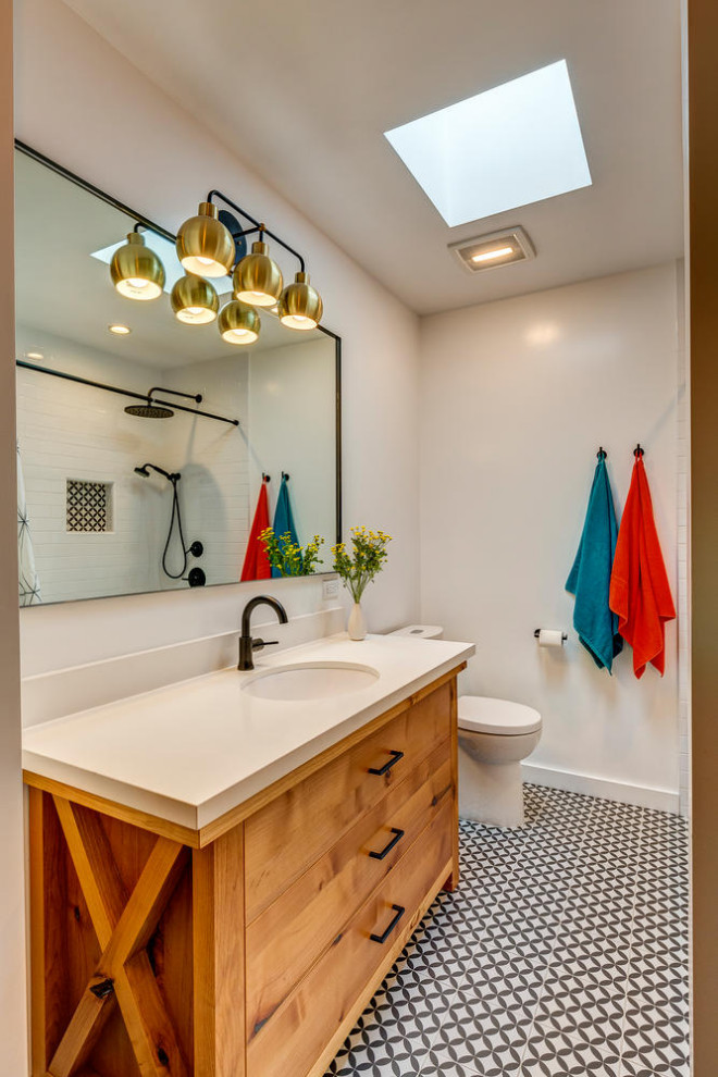 Photo of a mid-sized contemporary kids bathroom in Los Angeles with flat-panel cabinets, medium wood cabinets, white tile, ceramic tile, porcelain floors, an undermount sink, engineered quartz benchtops, black floor, a hinged shower door, white benchtops, a single vanity and a freestanding vanity.