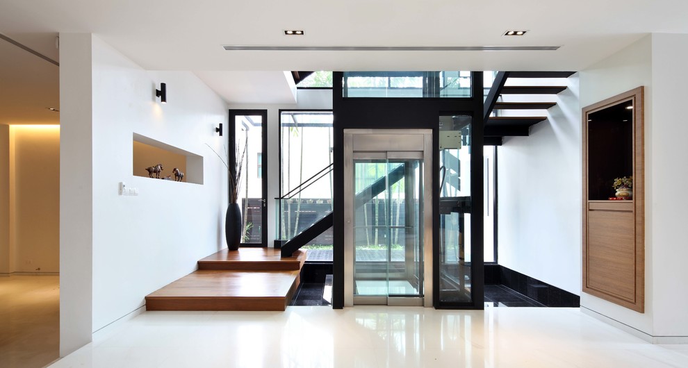Inspiration for a contemporary entryway in Singapore with white walls and white floor.