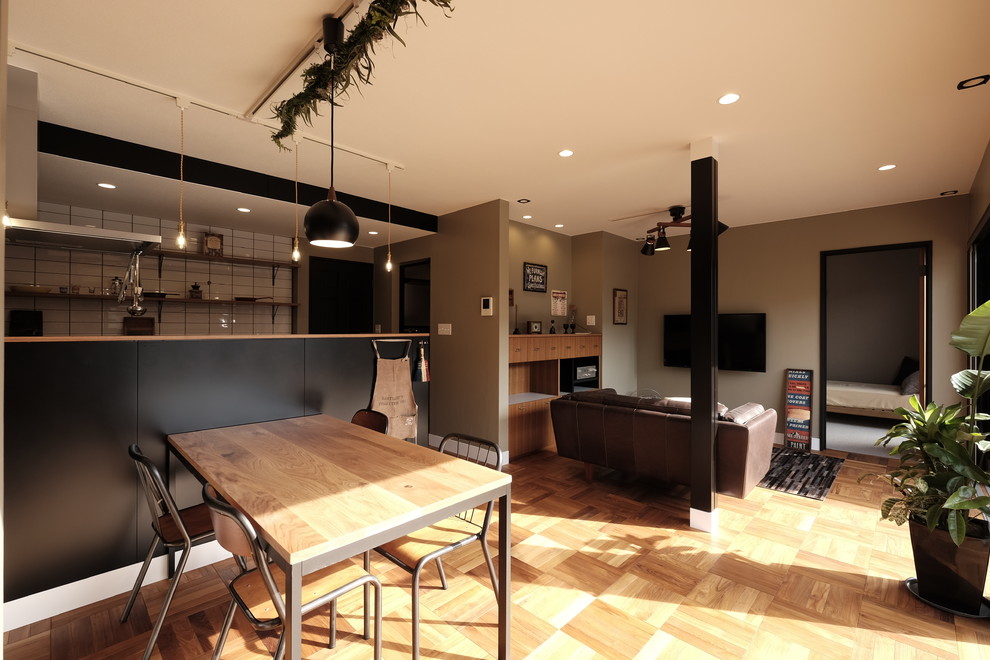 Idées déco pour une salle à manger industrielle avec un mur gris, un sol en bois brun et un sol marron.