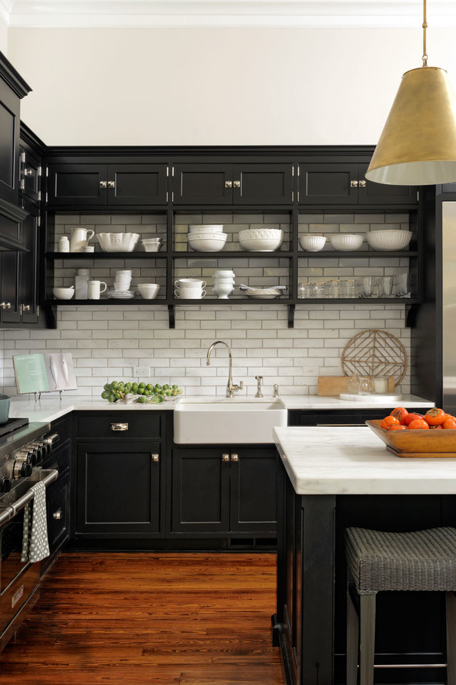 Eat-in kitchen - large transitional l-shaped medium tone wood floor and brown floor eat-in kitchen idea in DC Metro with a farmhouse sink, beaded inset cabinets, black cabinets, white backsplash, subway tile backsplash, stainless steel appliances, an island and quartzite countertops