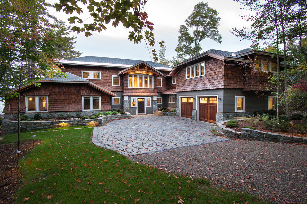 Arts and crafts two-storey grey house exterior in New York with wood siding, a hip roof and a shingle roof.