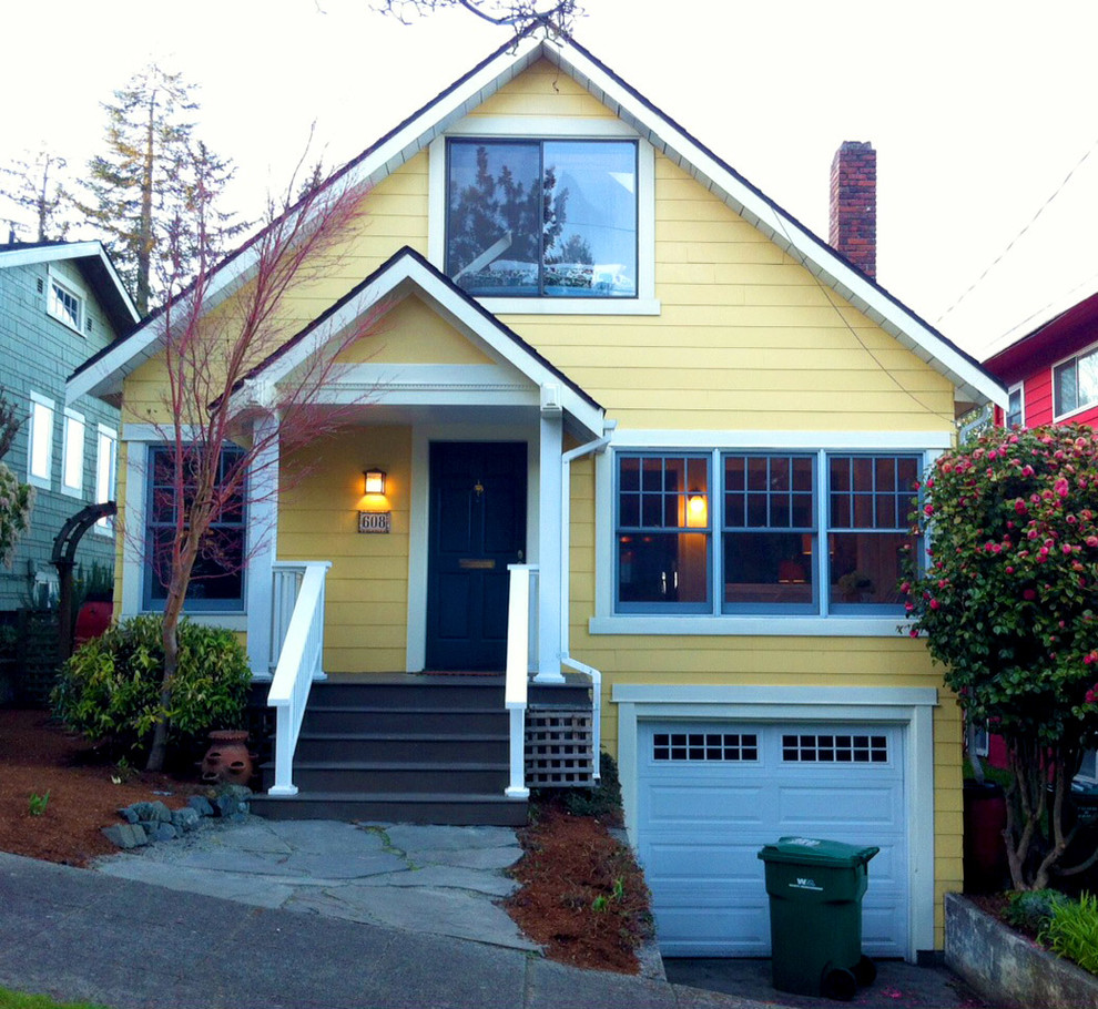 Inspiration for a mid-sized traditional two-storey yellow exterior in Seattle with wood siding and a gable roof.
