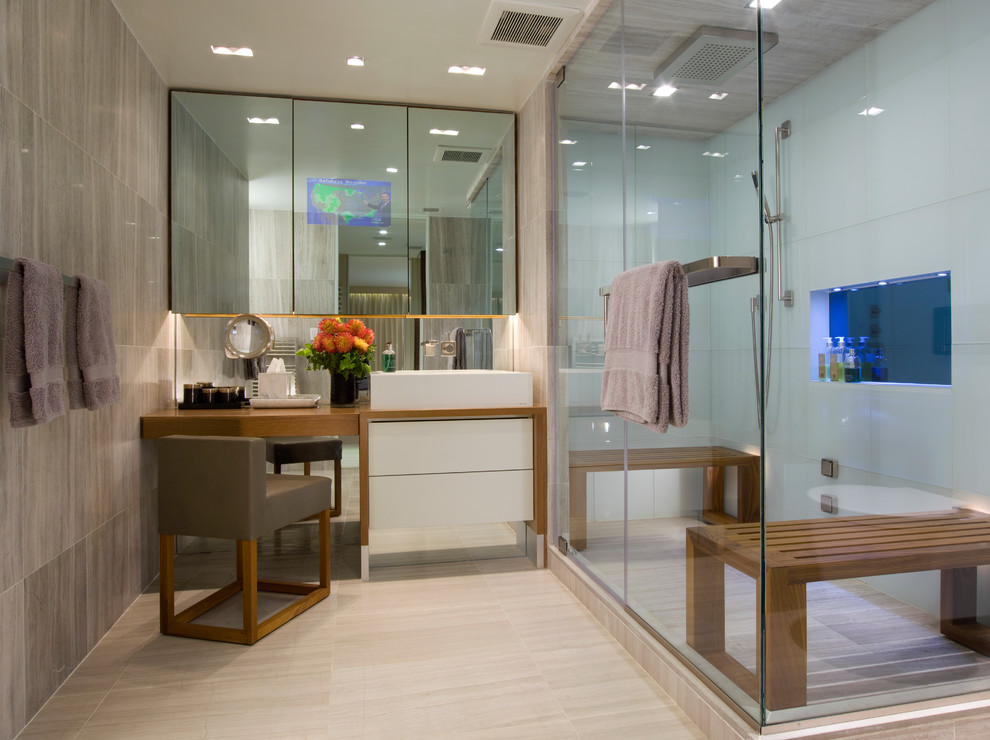 Inspiration for a mid-sized contemporary master bathroom in New York with furniture-like cabinets, white cabinets, a corner shower, white tile, glass tile, grey walls, porcelain floors, a vessel sink, wood benchtops, beige floor and a hinged shower door.