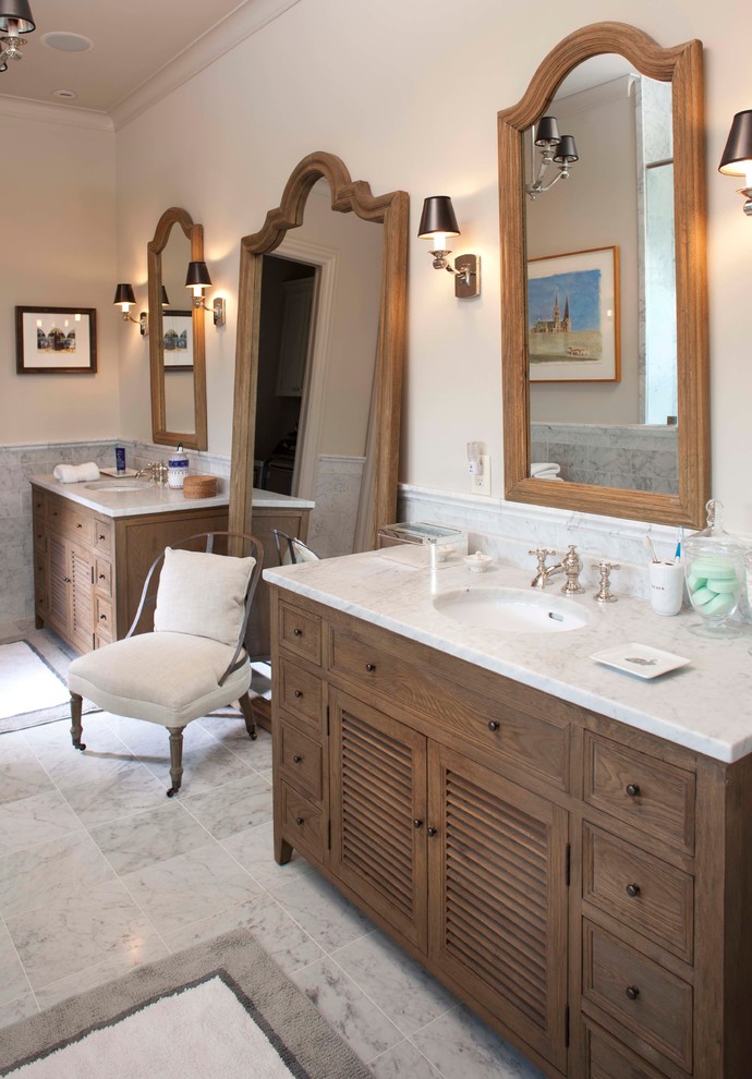 Photo of an expansive traditional master bathroom in Houston with recessed-panel cabinets, brown cabinets, marble floors, an undermount sink, marble benchtops, grey floor, white benchtops, a double vanity and a freestanding vanity.