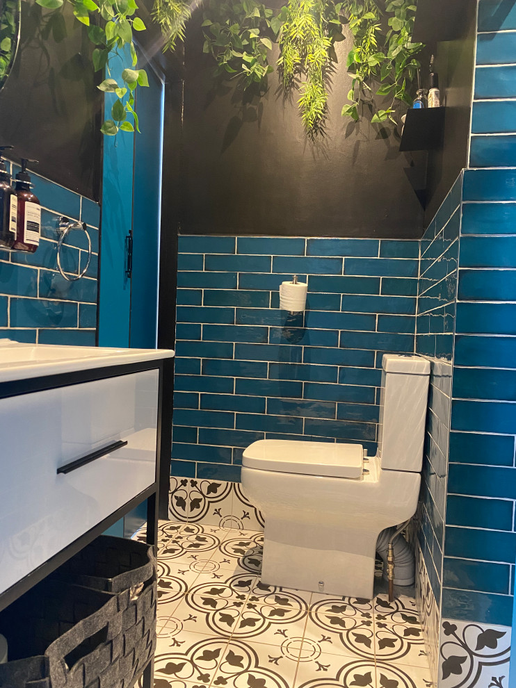Источник вдохновения для домашнего уюта: маленькая главная ванная комната в стиле фьюжн с белыми фасадами, открытым душем, унитазом-моноблоком, синей плиткой, керамической плиткой, черными стенами, полом из керамической плитки, накладной раковиной, белым полом, душем с распашными дверями, нишей, тумбой под одну раковину, встроенной тумбой и панелями на части стены для на участке и в саду