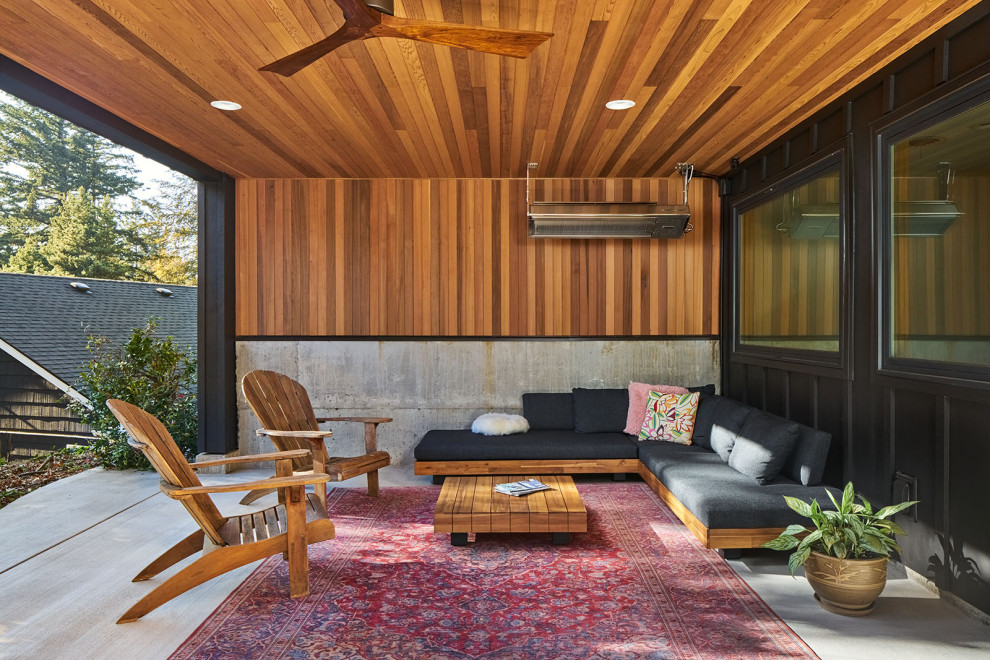 Inspiration for a large and black midcentury two floor detached house in Portland with wood cladding, a butterfly roof and board and batten cladding.