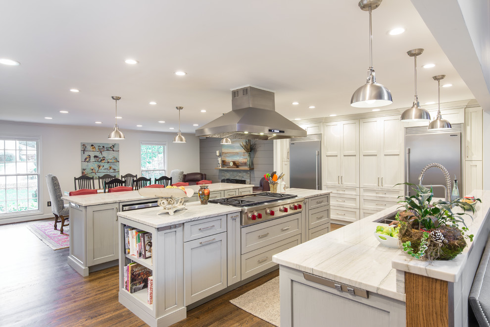Example of a large transitional single-wall medium tone wood floor and brown floor eat-in kitchen design with an undermount sink, shaker cabinets, white cabinets, marble countertops, multicolored backsplash, matchstick tile backsplash, stainless steel appliances and two islands