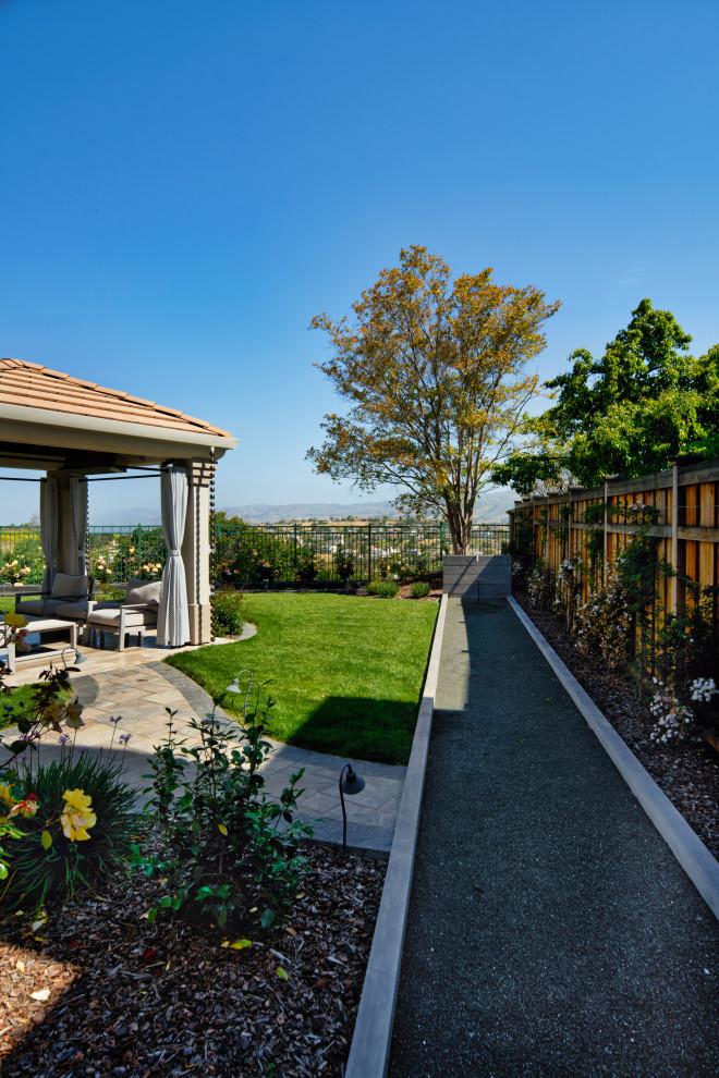 Große Mediterrane Pflanzenwand hinter dem Haus mit Sportplatz, direkter Sonneneinstrahlung, Betonboden und Holzzaun in San Francisco