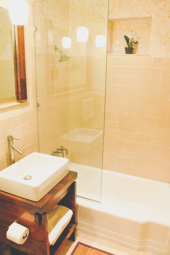 Idéer för små badrum, med skåp i mellenmörkt trä, ett badkar i en alkov, en toalettstol med separat cisternkåpa, beige kakel, keramikplattor, beige väggar, klinkergolv i keramik, ett piedestal handfat, bänkskiva i återvunnet glas, beiget golv och med dusch som är öppen