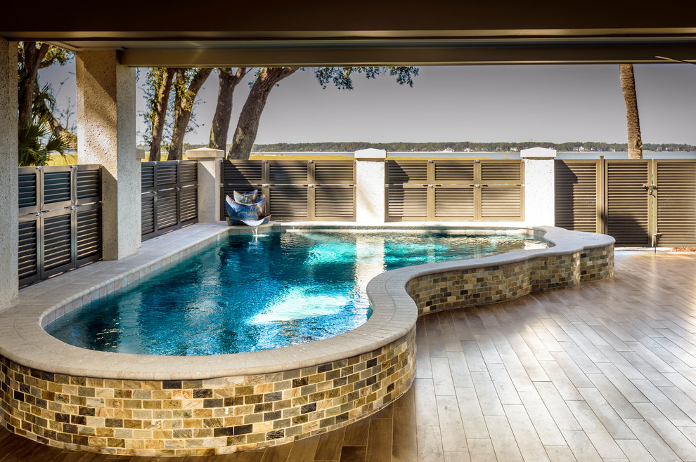 Photo of a small contemporary backyard custom-shaped aboveground pool in Charleston with a water feature and tile.
