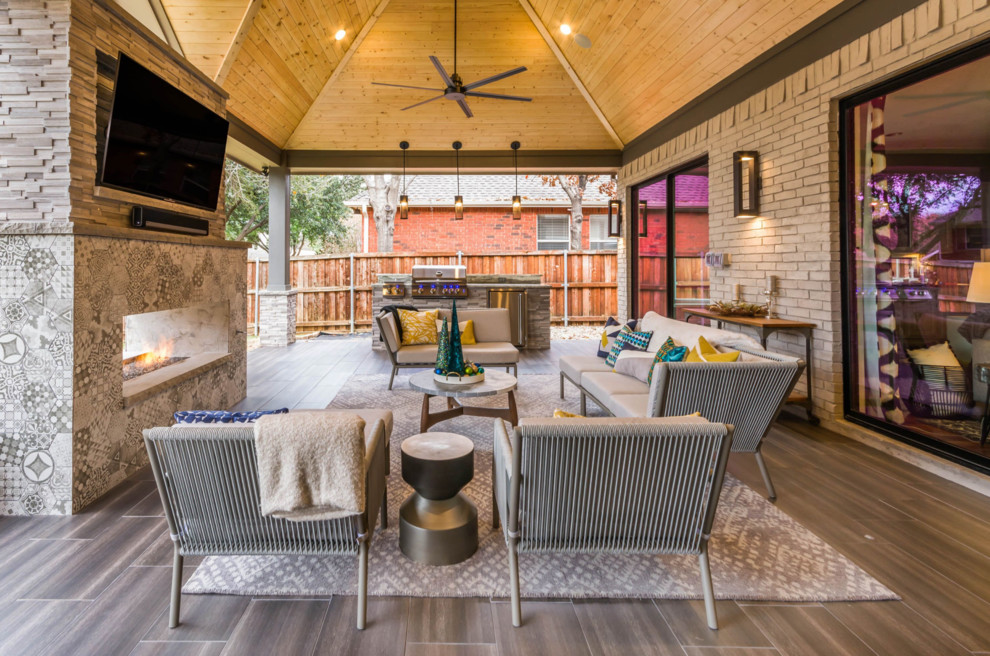 Photo of a mid-sized contemporary backyard patio in Houston with with fireplace, tile and a roof extension.