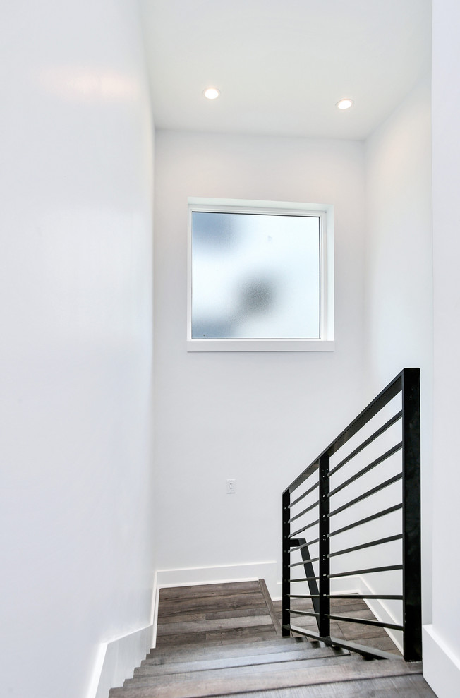 Mid-sized industrial wood l-shaped staircase in Tampa with wood risers and metal railing.