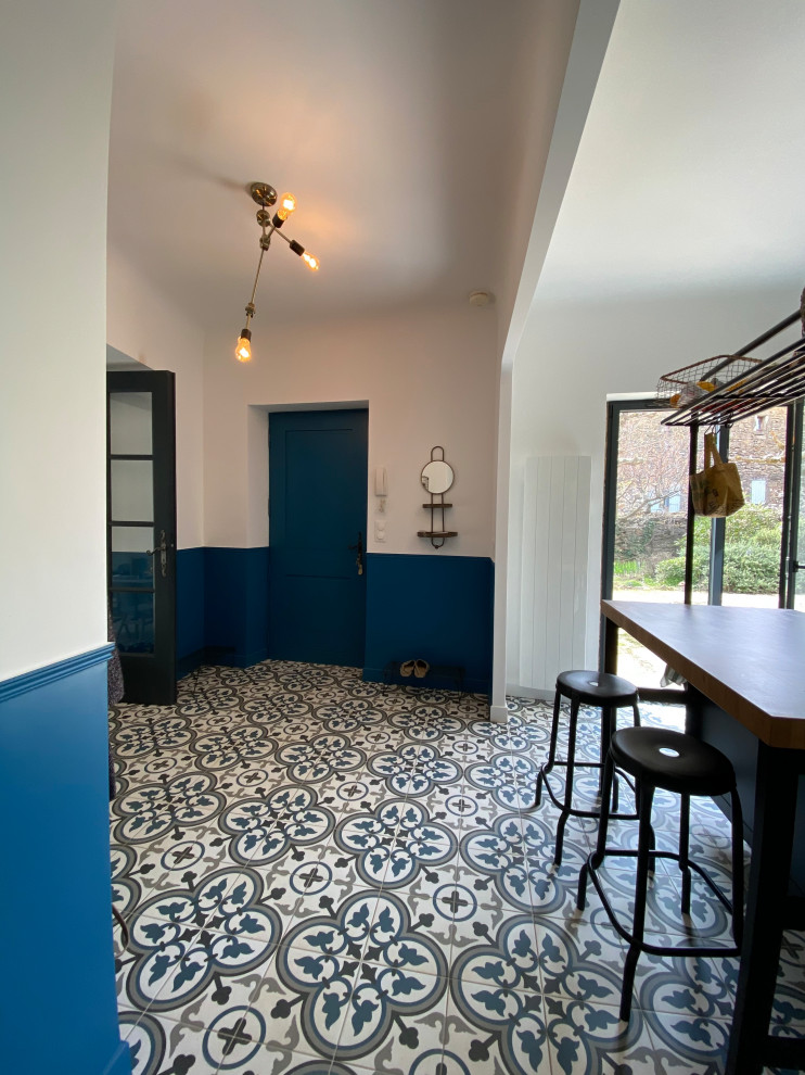 Diseño de entrada retro de tamaño medio con paredes azules, suelo de baldosas de cerámica, puerta simple, puerta azul y suelo multicolor