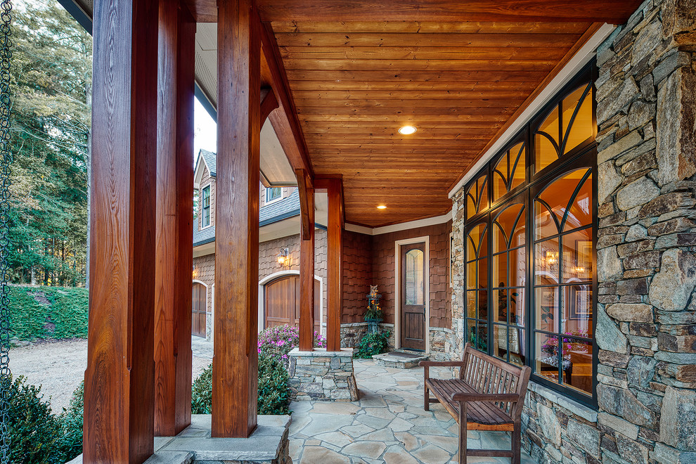 Inspiration for a traditional front yard verandah in Other with natural stone pavers and a roof extension.