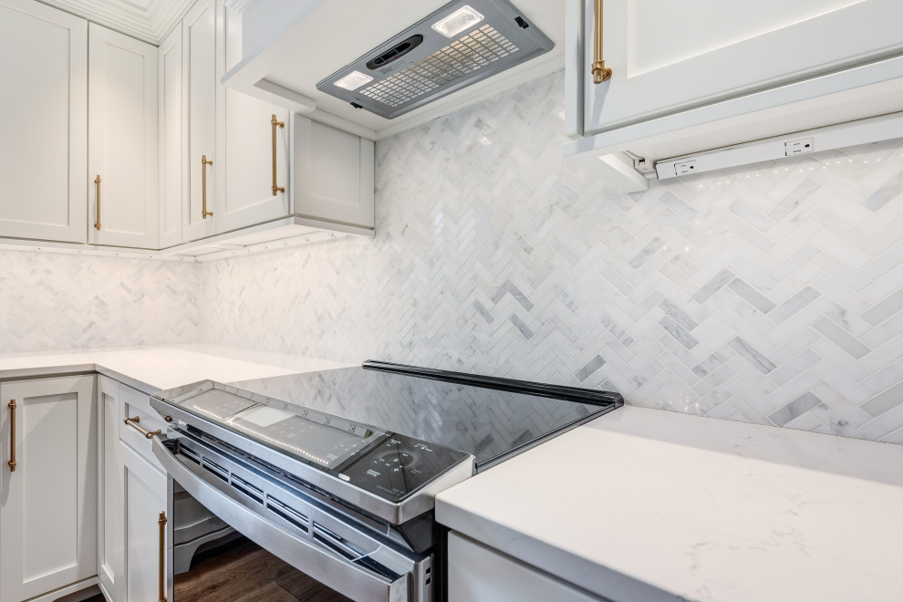 Eat-in kitchen - mid-sized transitional l-shaped light wood floor and brown floor eat-in kitchen idea in Chicago with a farmhouse sink, shaker cabinets, white cabinets, quartzite countertops, white backsplash, glass tile backsplash, colored appliances, an island and white countertops
