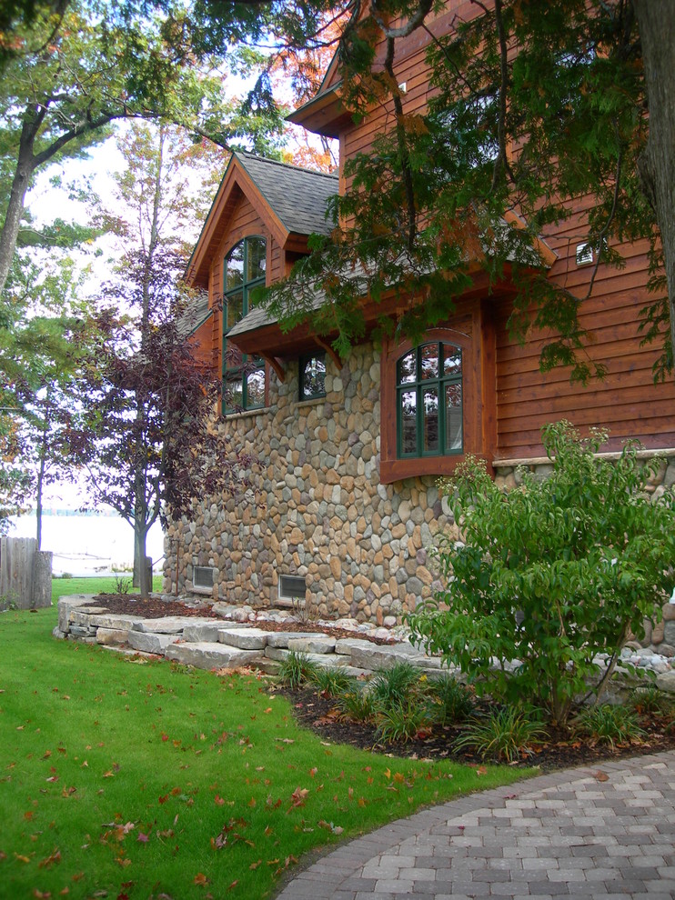 This is an example of an arts and crafts three-storey brown exterior in Other with wood siding and a gable roof.