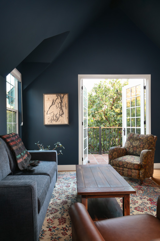 Immagine di una camera degli ospiti chic di medie dimensioni con pareti blu, pavimento in legno massello medio, pavimento marrone e soffitto a volta