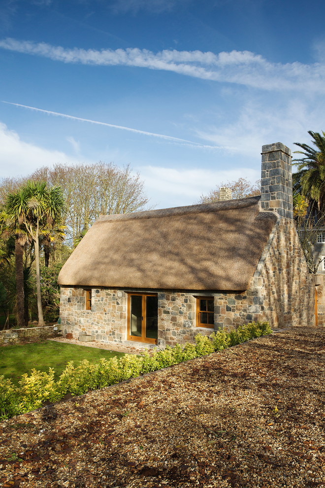 Inspiration for a country one-storey exterior in Channel Islands with stone veneer.