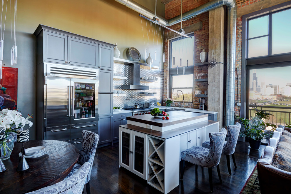 Inspiration for a mid-sized transitional l-shaped dark wood floor and brown floor eat-in kitchen remodel in Chicago with a farmhouse sink, flat-panel cabinets, gray cabinets, quartz countertops, metallic backsplash, metal backsplash, stainless steel appliances and an island