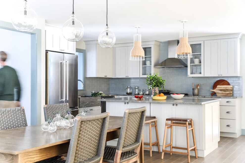 Design ideas for a mid-sized beach style l-shaped open plan kitchen in Portland Maine with an integrated sink, shaker cabinets, grey cabinets, granite benchtops, blue splashback, brick splashback, stainless steel appliances, medium hardwood floors, with island and grey benchtop.