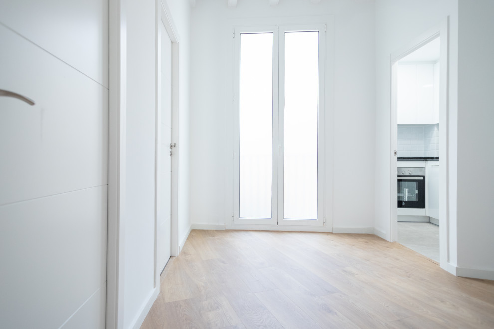 Ejemplo de salón cerrado actual de tamaño medio sin chimenea con paredes blancas, suelo de madera en tonos medios y suelo marrón