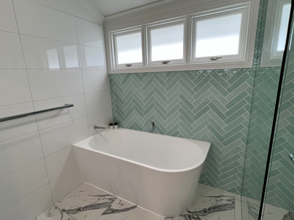 This is an example of a mid-sized beach style kids bathroom in Brisbane with beaded inset cabinets, medium wood cabinets, a corner tub, a corner shower, a two-piece toilet, white tile, ceramic tile, white walls, ceramic floors, a drop-in sink, solid surface benchtops, white floor, a hinged shower door, white benchtops, a single vanity and a floating vanity.