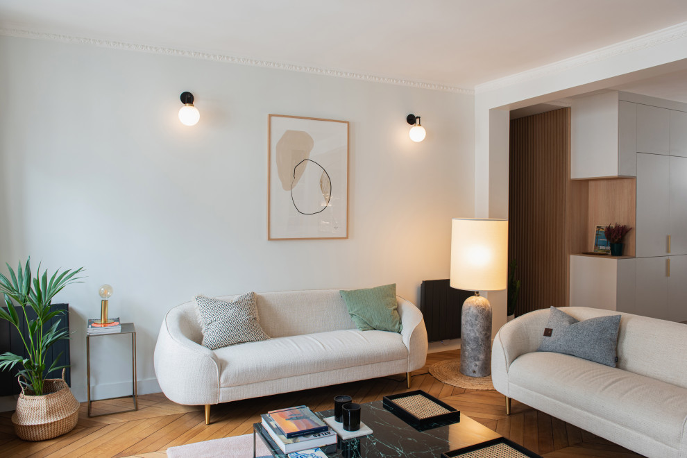 Mittelgroßes, Offenes Modernes Wohnzimmer mit Hausbar, beiger Wandfarbe, hellem Holzboden, Kamin, Kaminumrandung aus Stein und TV-Wand in Paris