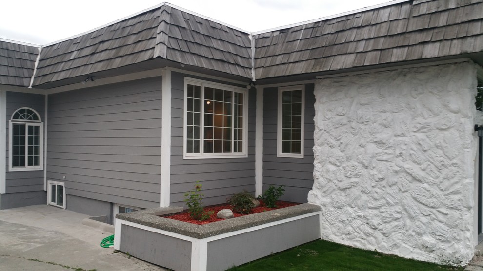 Photo of a mid-sized traditional one-storey grey house exterior in Other with vinyl siding and a shingle roof.