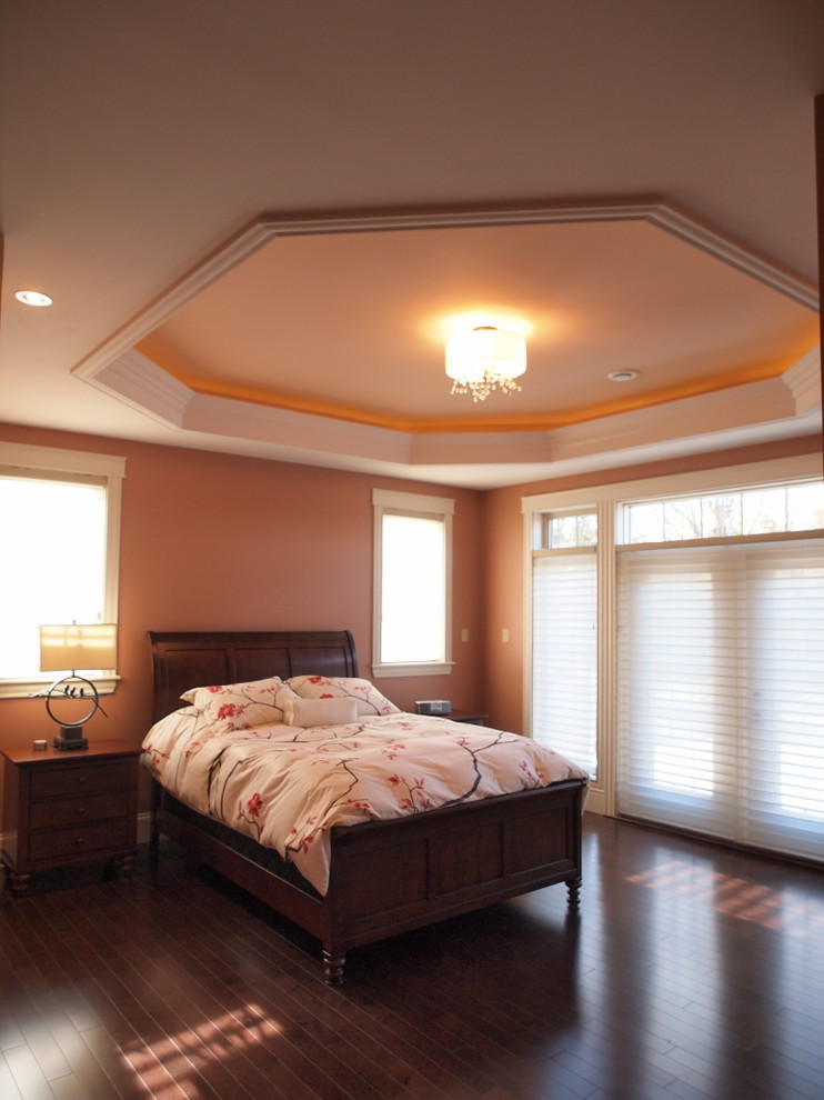 This is an example of a large transitional master bedroom in Other with orange walls, dark hardwood floors and brown floor.