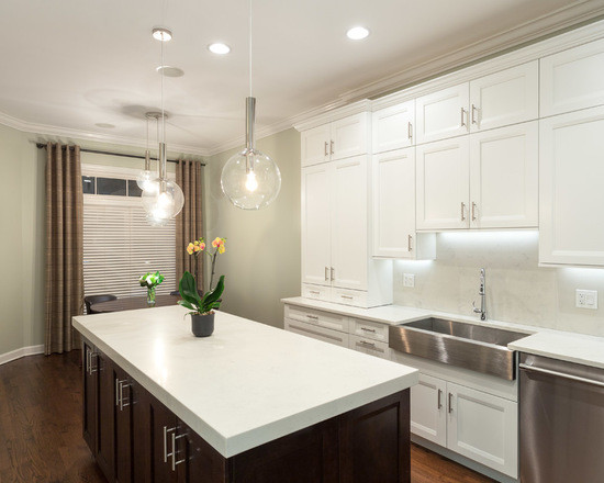 Large transitional l-shaped dark wood floor eat-in kitchen photo in Chicago with a farmhouse sink, shaker cabinets, white cabinets, marble countertops, white backsplash, subway tile backsplash, stainless steel appliances and an island
