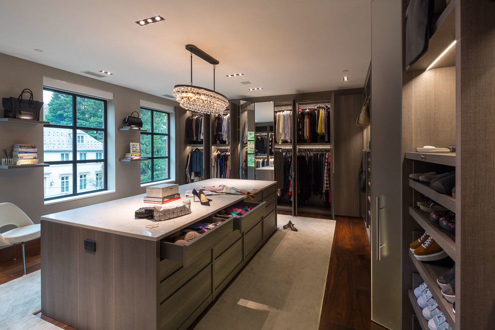 Design ideas for an expansive contemporary women's walk-in wardrobe in DC Metro with flat-panel cabinets, medium wood cabinets, carpet and beige floor.