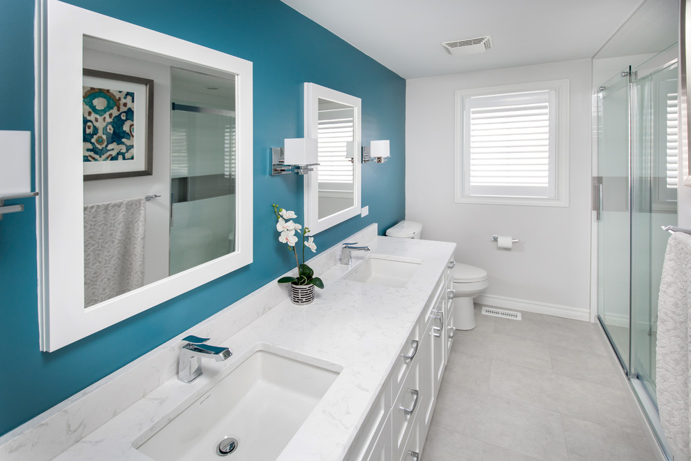 Photo of a mid-sized transitional bathroom in Toronto with an undermount sink, shaker cabinets, white cabinets, engineered quartz benchtops, an alcove shower, a two-piece toilet, white tile, ceramic tile, grey walls and linoleum floors.
