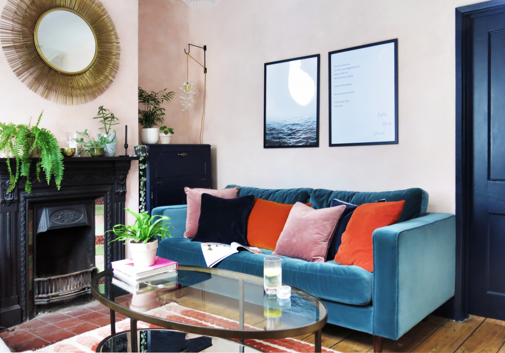 Idee per un piccolo soggiorno minimal chiuso con pareti rosa, pavimento in legno massello medio, camino classico e cornice del camino piastrellata