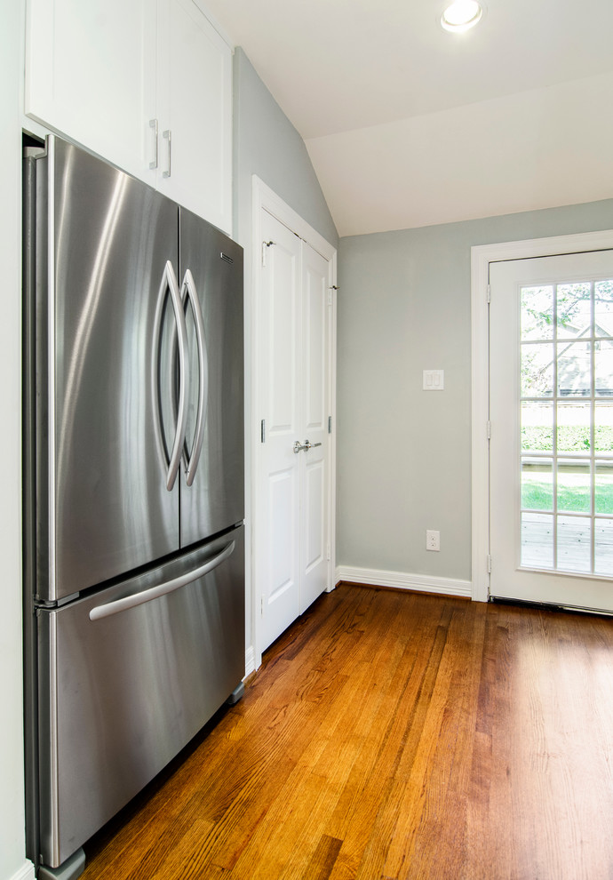 Inspiration for a transitional galley eat-in kitchen remodel in Dallas with an undermount sink, shaker cabinets, white cabinets, marble countertops, white backsplash, subway tile backsplash and stainless steel appliances