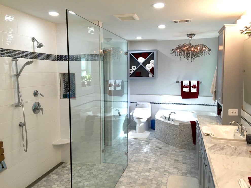 Photo of a mid-sized transitional master bathroom in Dallas with recessed-panel cabinets, grey cabinets, a corner tub, a curbless shower, a one-piece toilet, gray tile, mosaic tile, grey walls, mosaic tile floors, a drop-in sink, granite benchtops, grey floor and an open shower.