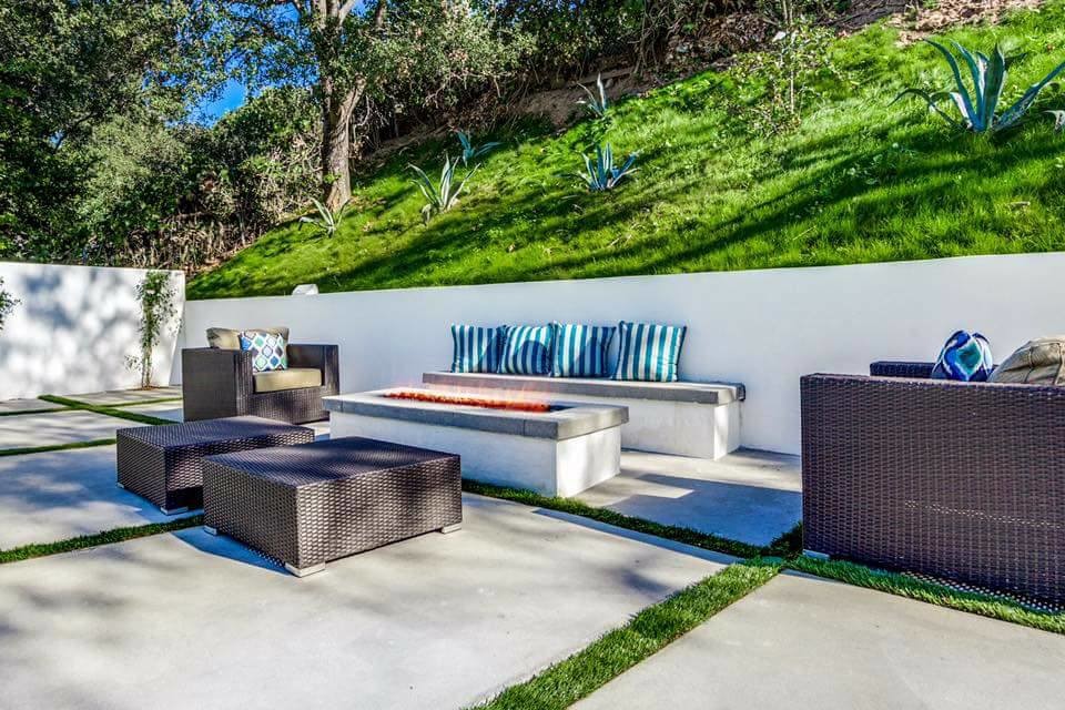 This is an example of a mid-sized contemporary backyard patio in Los Angeles with a fire feature, concrete slab and no cover.
