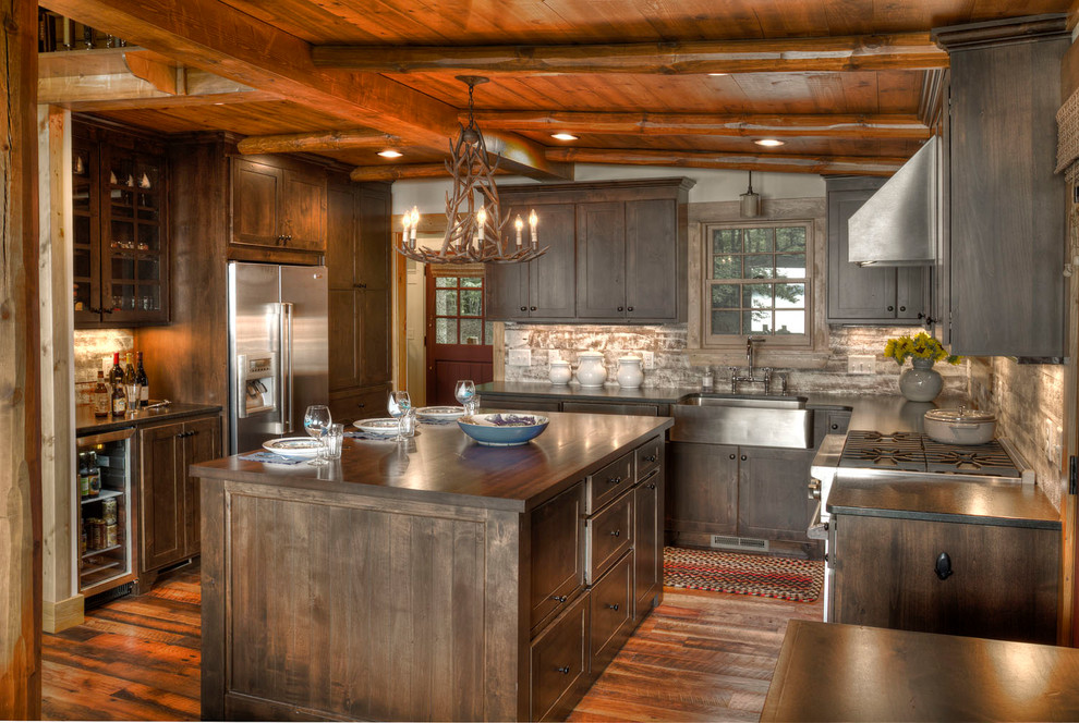 Mountain style u-shaped dark wood floor kitchen photo in Minneapolis with a farmhouse sink, shaker cabinets, dark wood cabinets, stainless steel appliances and an island