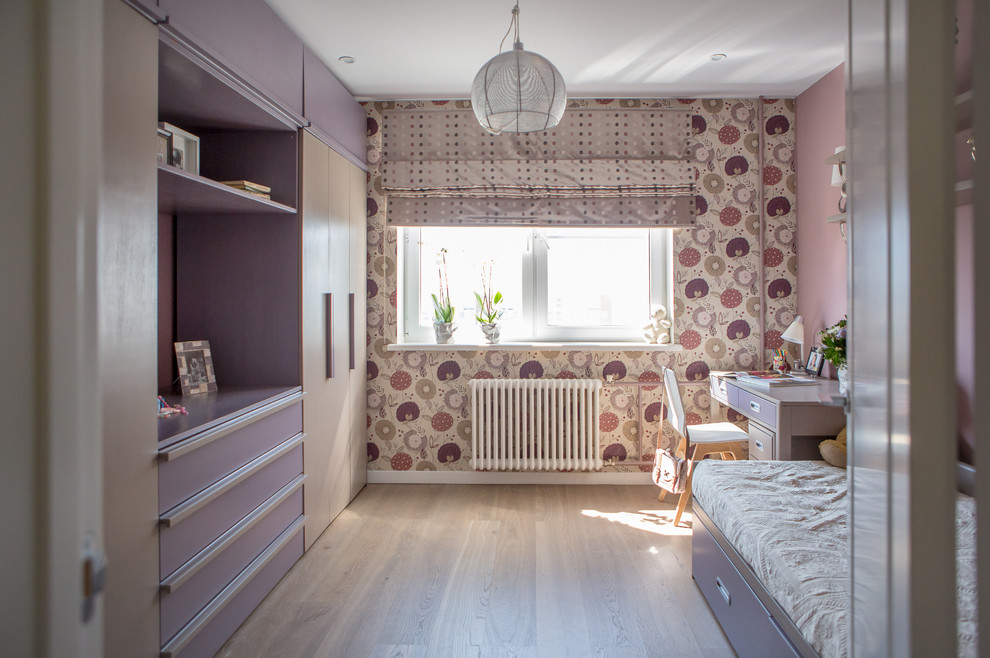 This is an example of a contemporary kids' bedroom for girls in Moscow with light hardwood floors and multi-coloured walls.