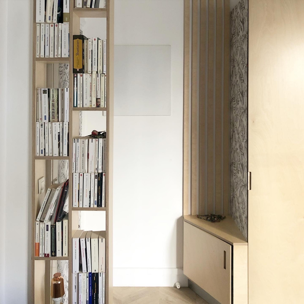 Example of a small trendy light wood floor, beige floor and wallpaper front door design in Paris with white walls