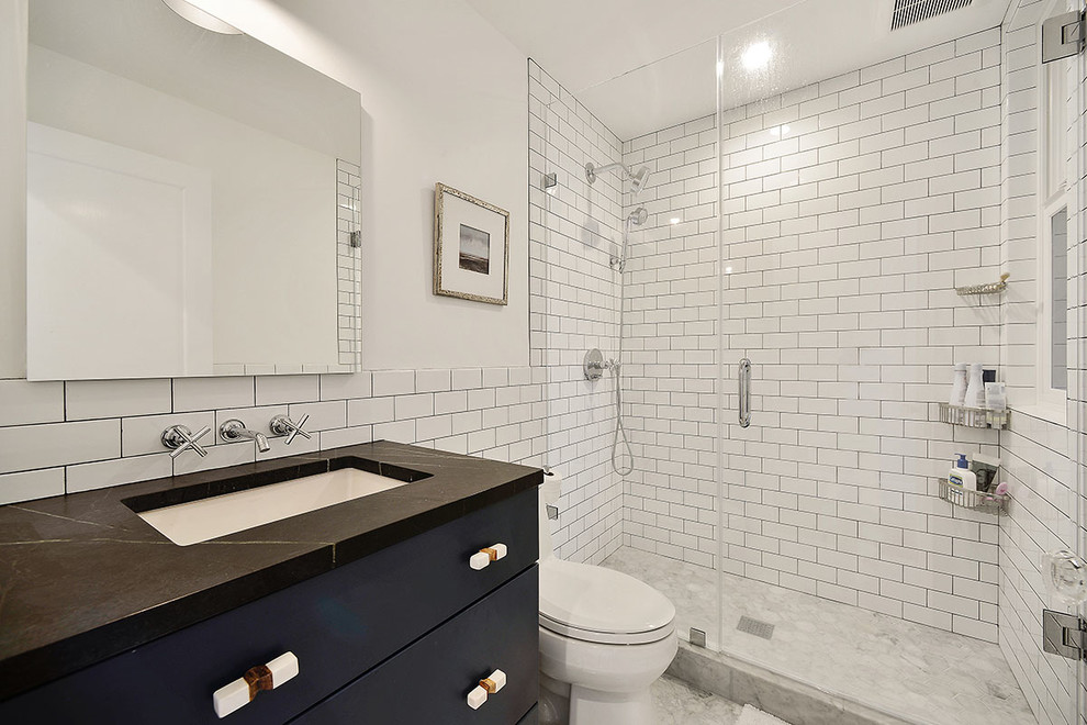 Photo of a small contemporary master bathroom in San Francisco with white walls, marble floors, a wall-mount sink, flat-panel cabinets, black cabinets, an alcove shower, a one-piece toilet, white tile, subway tile, soapstone benchtops, grey floor and a hinged shower door.