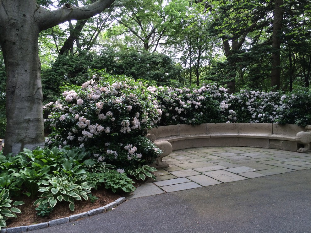 This is an example of a traditional courtyard partial sun formal garden for spring in Boston with natural stone pavers.