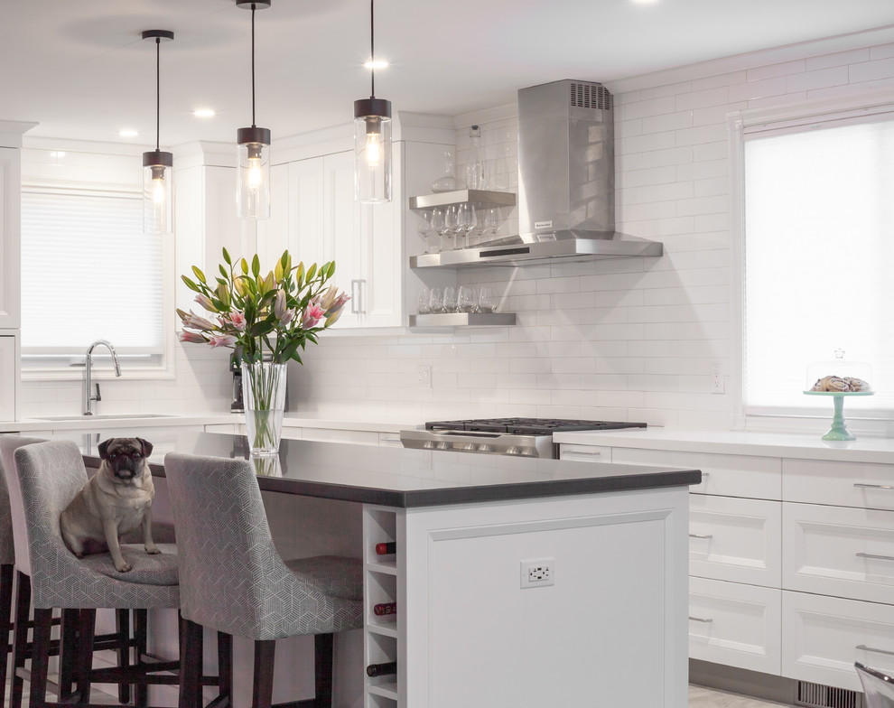 Large transitional l-shaped vinyl floor and white floor open concept kitchen photo in Toronto with an undermount sink, recessed-panel cabinets, white cabinets, quartz countertops, white backsplash, ceramic backsplash, stainless steel appliances, an island and white countertops