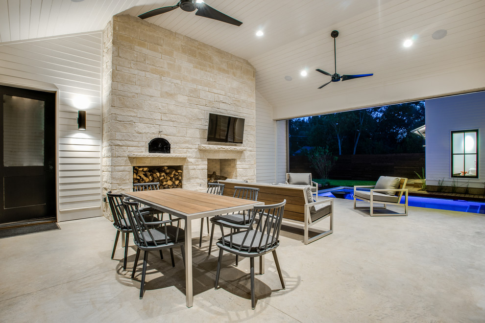 Design ideas for a country backyard patio in Dallas with a roof extension and with fireplace.