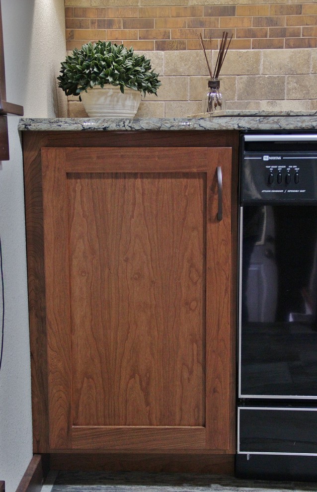Mid-sized transitional galley ceramic tile enclosed kitchen photo with an undermount sink, shaker cabinets, medium tone wood cabinets, quartz countertops, beige backsplash, stone tile backsplash, stainless steel appliances and a peninsula